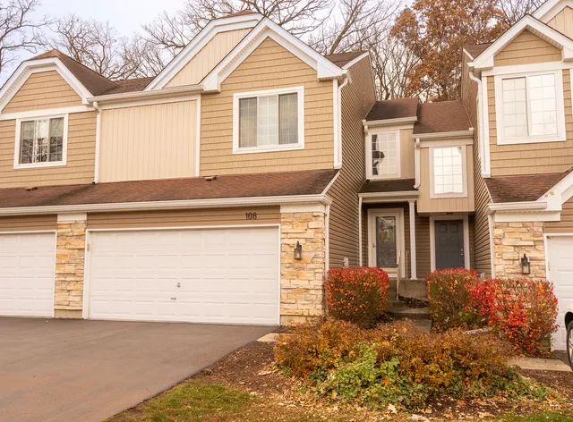 a view of a house with a yard and potted plants