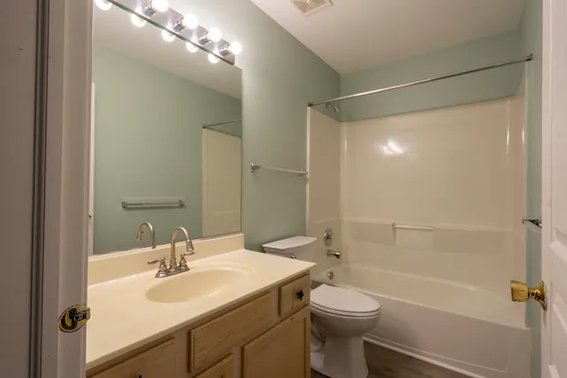 a bathroom with a sink toilet vanity and shower