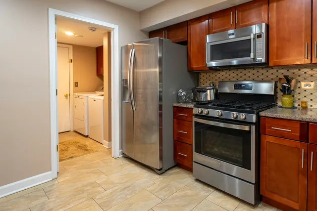 a kitchen with stainless steel appliances granite countertop a stove microwave and refrigerator