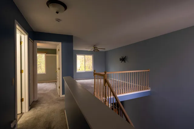 a view of a hallway with windows and stairs