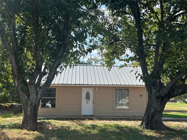 a view of a house with a tree and wooden fence