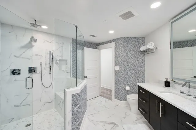 a bedroom with a bed and a flat tv screen on the dresser