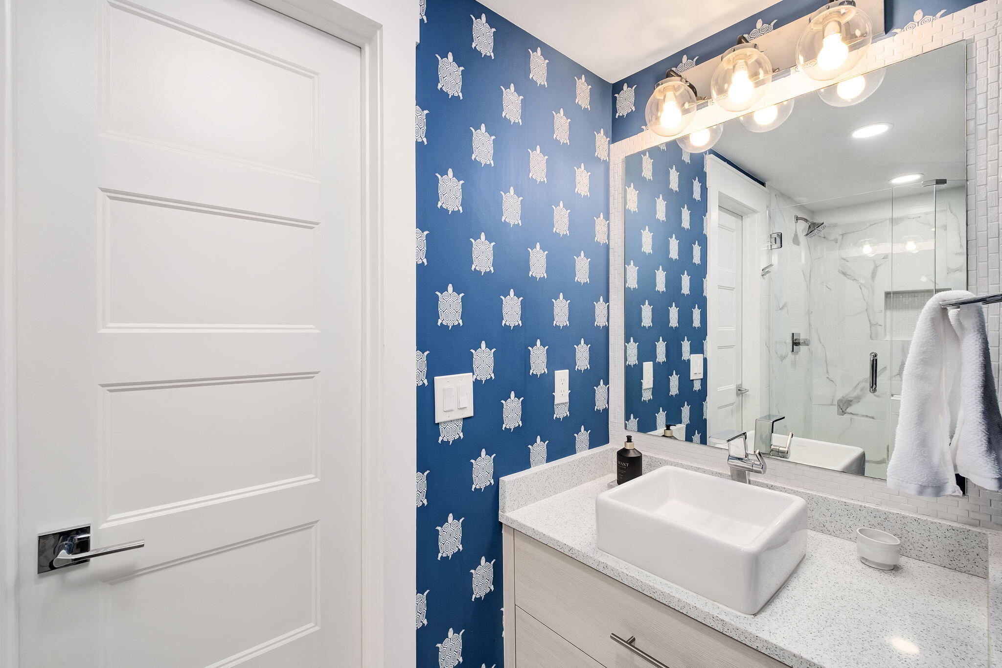 320 Harbor Boulevard, Unit A305 Destin, FL 32541 - Photo 36 of 71 a bathroom with a sink a mirror and a shower