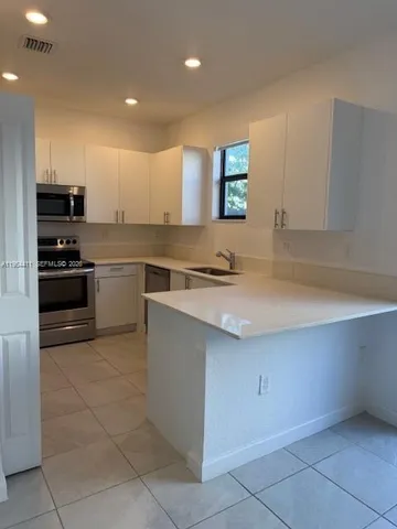 a kitchen with stainless steel appliances granite countertop a sink and a stove