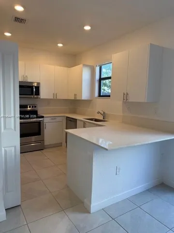 a kitchen with stainless steel appliances granite countertop a sink and a stove