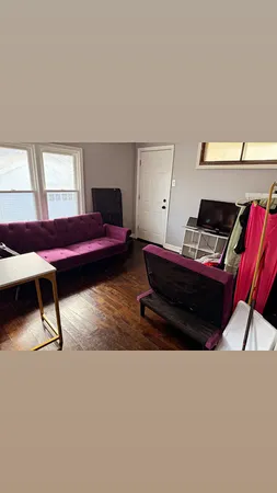 a living room with a bed furniture and a window