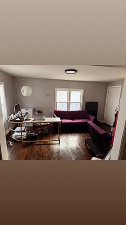 a living room with furniture gym equipment and view of kitchen
