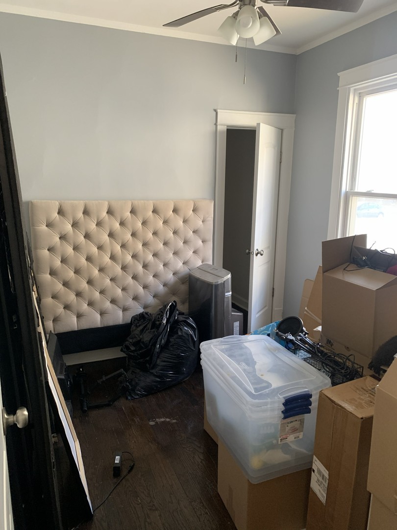 10529 South Perry Avenue Chicago, IL 60628 - Photo 10 of 17 a bedroom with a bed and a chandelier