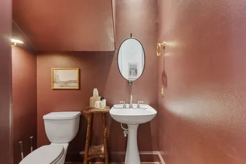 a bathroom with a toilet sink and mirror