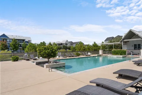 a view of a swimming pool and a chairs in front of house