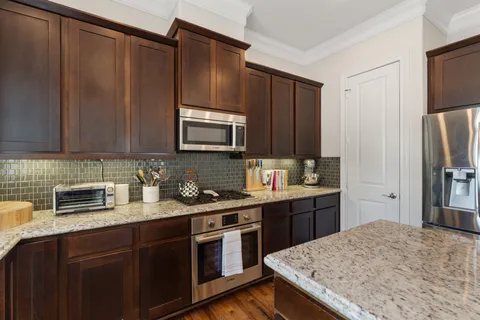a kitchen with stainless steel appliances granite countertop a stove refrigerator sink and microwave