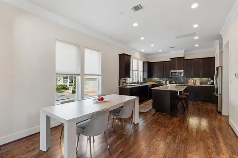 a kitchen with a dining table chairs refrigerator and cabinets