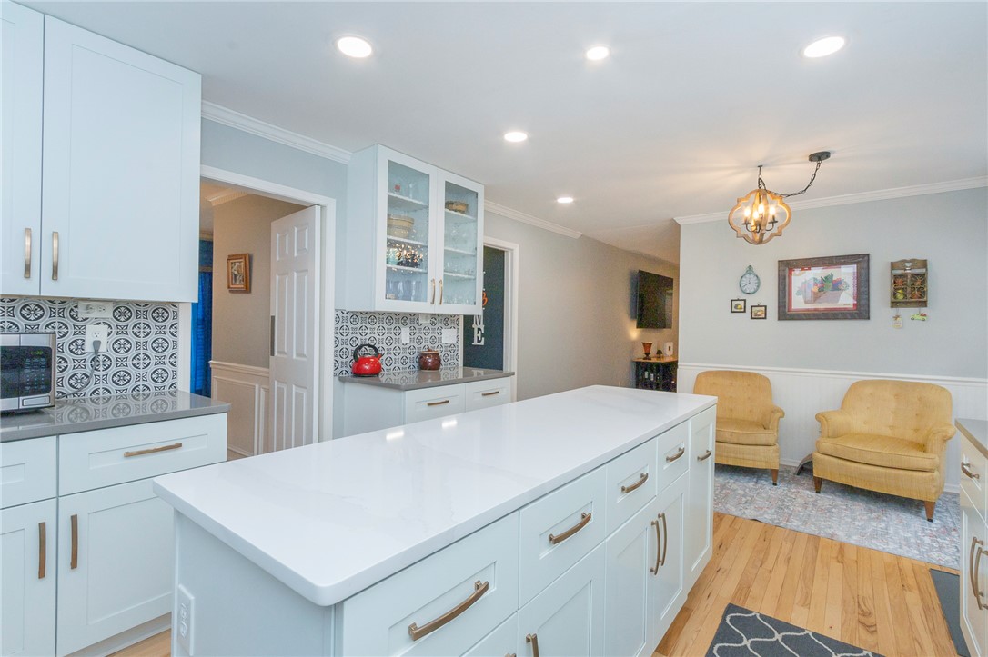 203 Oak Hollow Pendleton, SC 29670 - Photo 11 of 50 A well-lit kitchen with a spacious island, crown molding, and hardwood flooring.