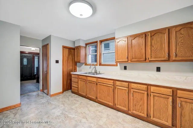 a view of a kitchen with stainless steel appliances granite countertop a sink and dishwasher with wooden cabinets