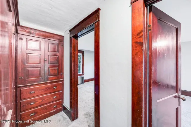 a view of an empty room with window and bathroom