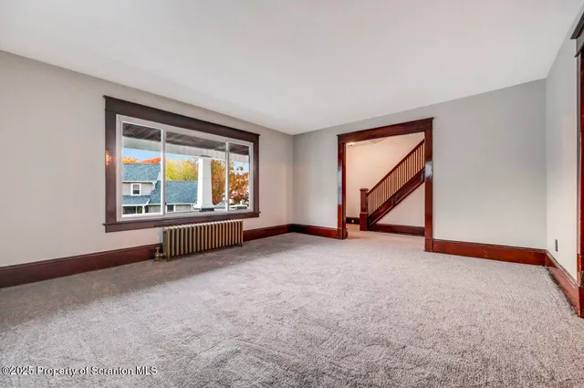 an empty room with a fireplace and a window