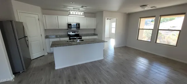 a kitchen with kitchen island white cabinets and wooden floor