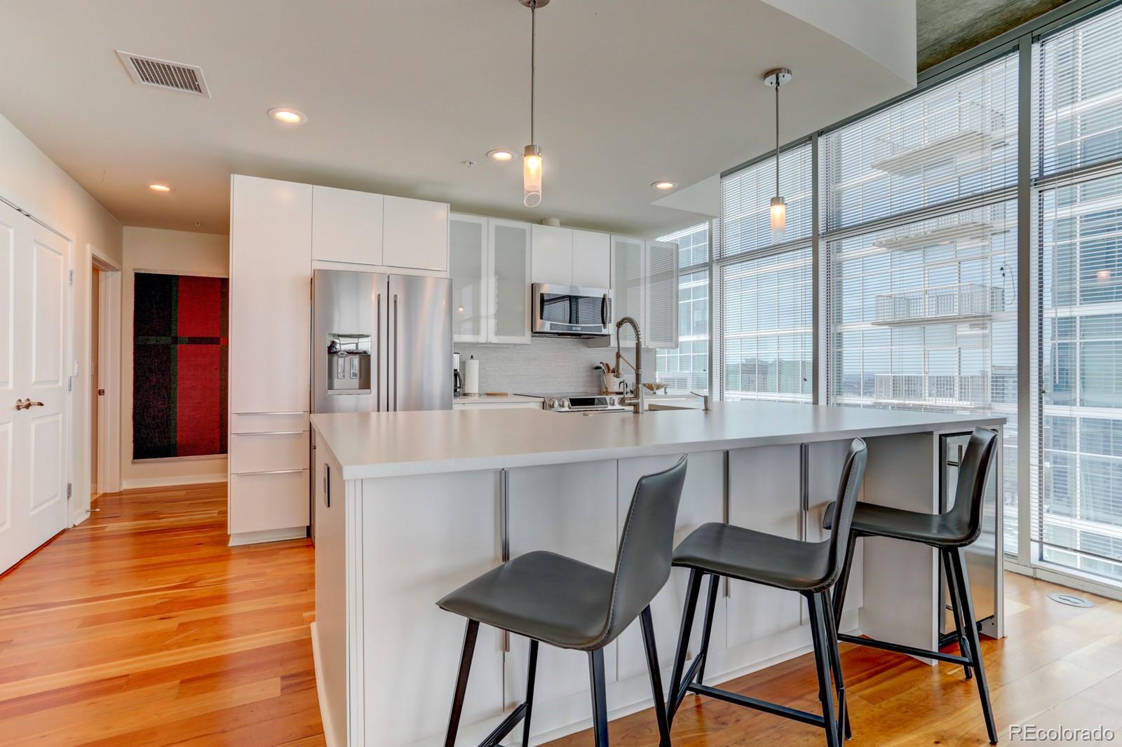 a kitchen with stainless steel appliances kitchen island granite countertop a dining table chairs and sink