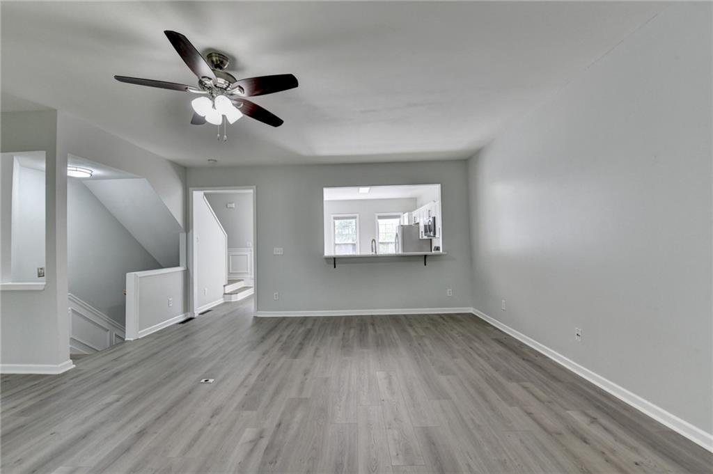 3977 Howell Park Road Duluth, GA 30096 - Photo 12 of 25 an empty room with wooden floor fan and windows