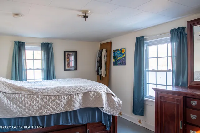 a bedroom with a bed and a dresser with mirror