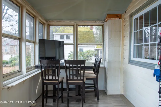 a view of a dining room with furniture large windows and backyard