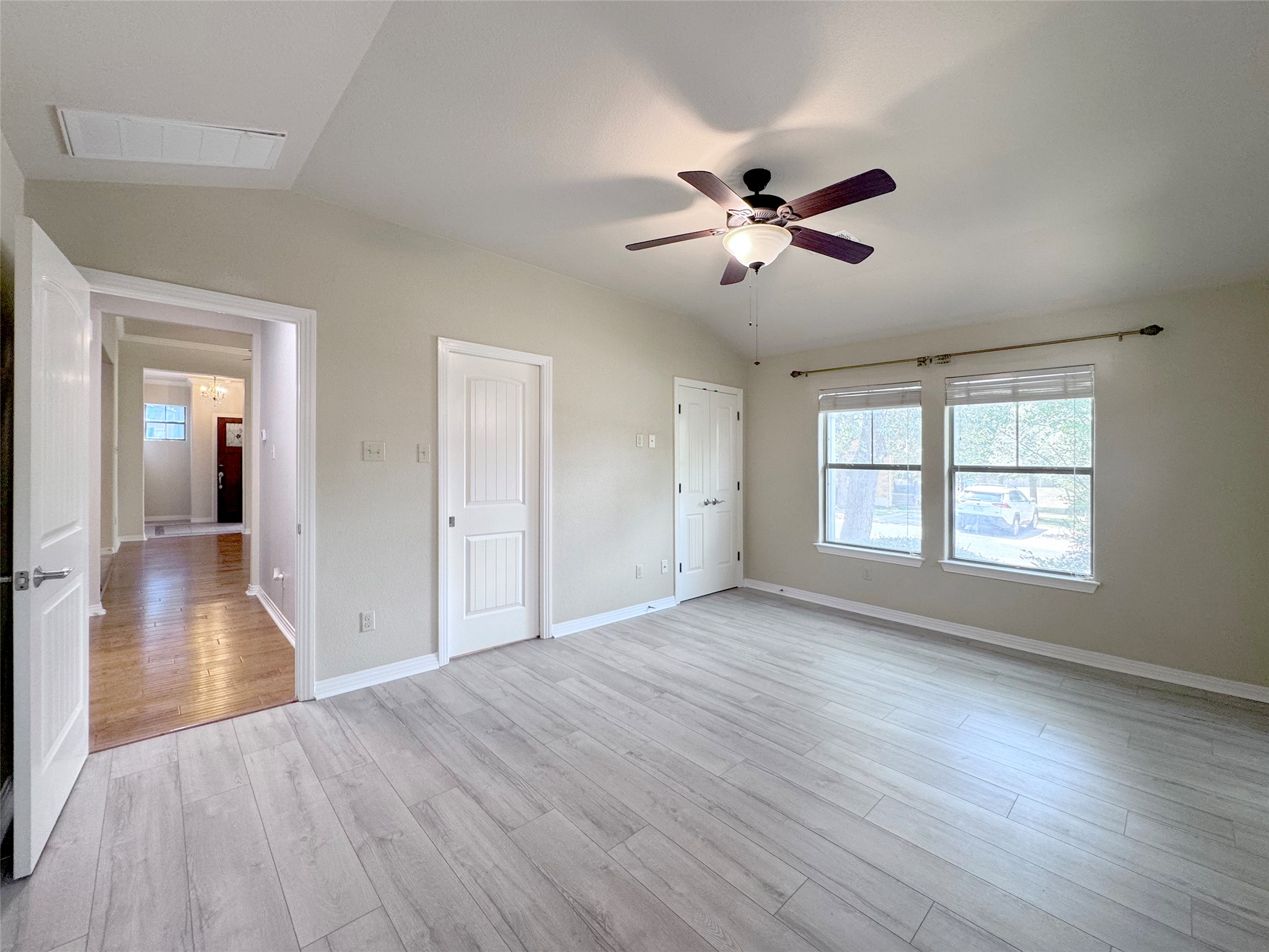 9707 Anderson Mill Road, Unit 21 Austin, TX 78750 - Photo 14 of 27 Gleaming plank flooring and vaulted overheads enhance this inviting bedroom.