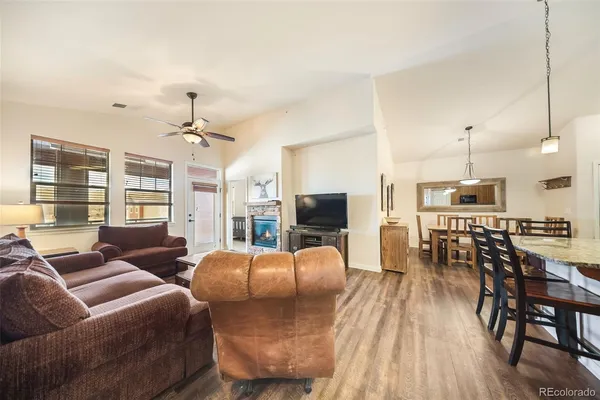 a living room with furniture kitchen and a wooden floor