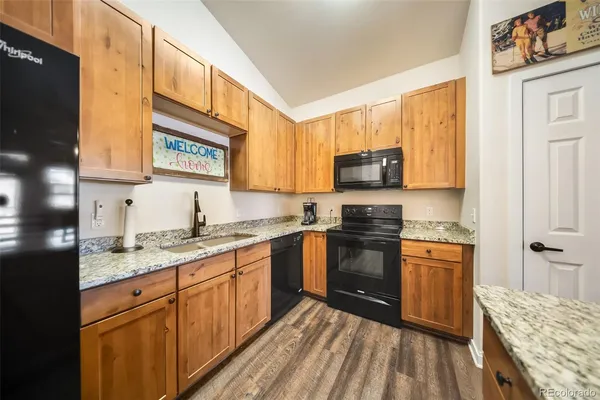a kitchen with stainless steel appliances granite countertop wooden cabinets a stove top oven a sink and dishwasher