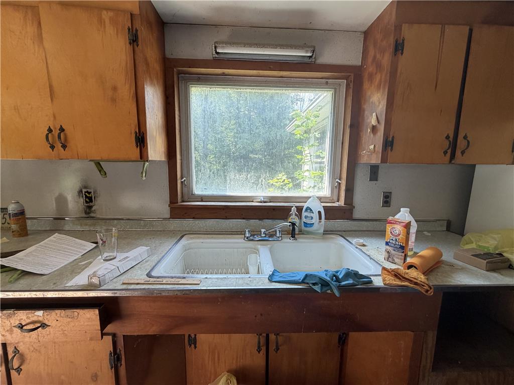 5114 Three Lakes Road New Milford, PA 18834 - Photo 14 of 55 A classic kitchen workspace features wooden cabinetry and a double sink beneath a large window.