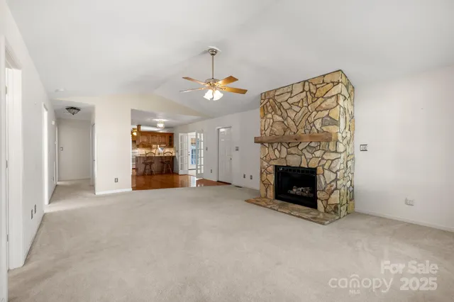 an empty room with windows and fireplace
