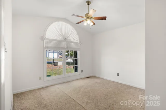 an empty room with closet and a chandelier fan