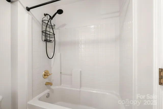 an empty room with chandelier fan and windows