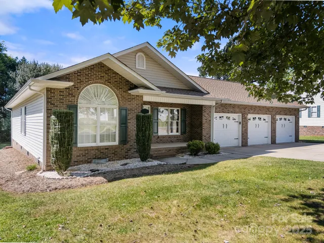 a view of a house with a yard and tree s