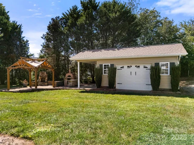 a view of a white house with a big yard and large trees