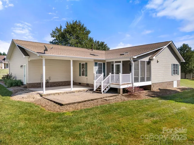 a view of a house with a patio and a yard