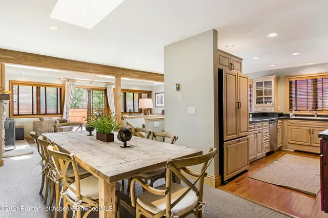 a kitchen with granite countertop a refrigerator a stove a dining table and chairs