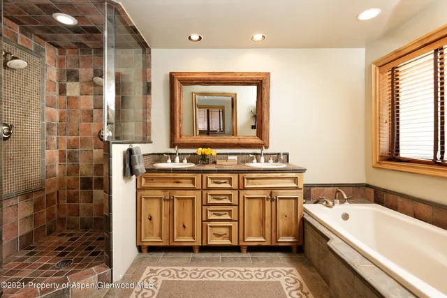 a bathroom with a tub sink and mirror