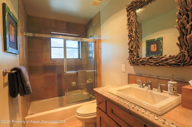 a bathroom with a granite countertop sink toilet and shower