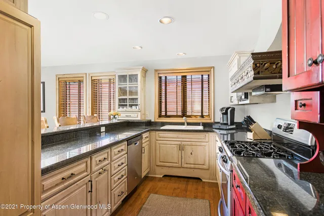 a kitchen with stainless steel appliances granite countertop a stove a sink and a refrigerator