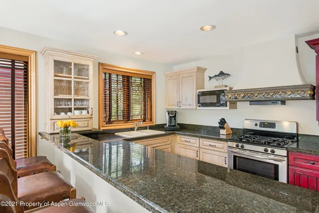 a kitchen with stainless steel appliances granite countertop a sink and a stove