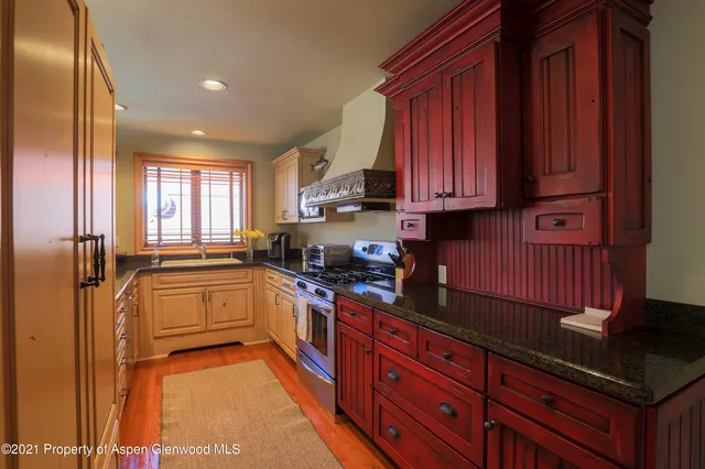 a kitchen with granite countertop wooden cabinets stainless steel appliances a sink and a window