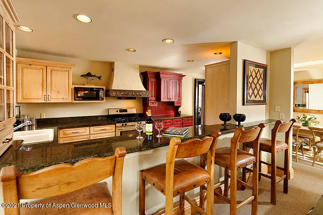 a kitchen with stainless steel appliances kitchen island granite countertop a table and chairs in it