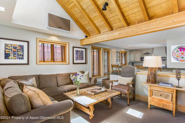 a living room with furniture a flat screen tv and kitchen view