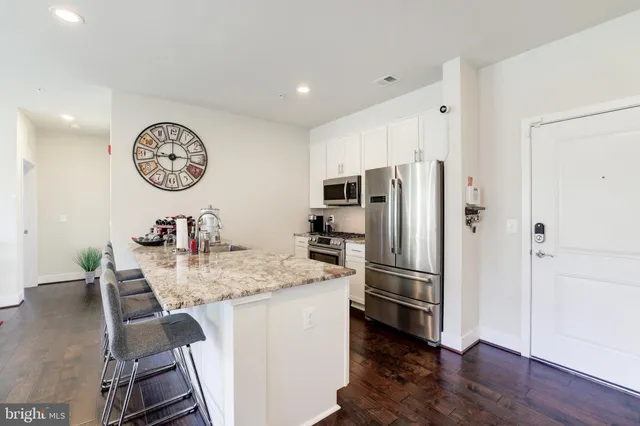a kitchen with stainless steel appliances granite countertop a refrigerator and a stove top oven
