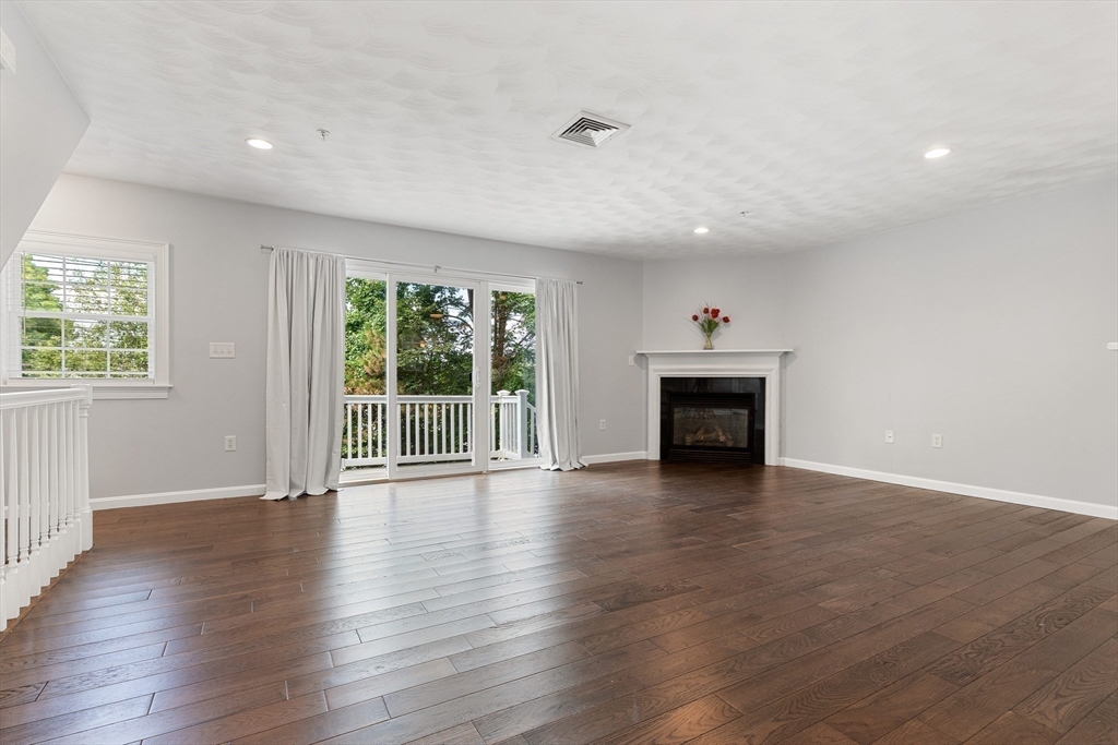 2 Ricciuti Drive, Unit 9 Quincy, MA 02169 - Photo 7 of 40 an empty room with wooden floor and windows