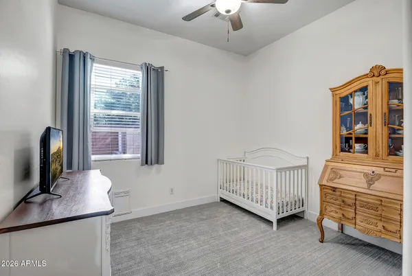 a bedroom with a bed a window and dresser
