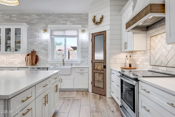 a kitchen with kitchen island granite countertop a sink cabinets and wooden floor