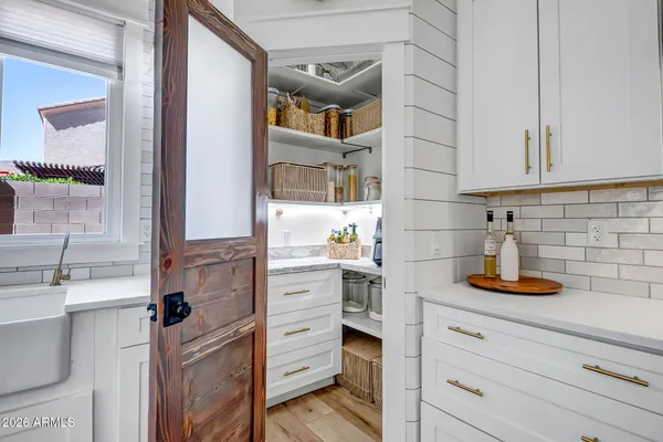 a kitchen with cabinets stainless steel appliances a sink and wooden floor