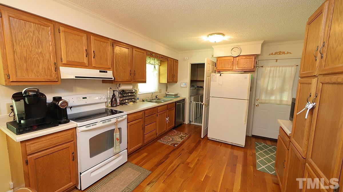 7121 Riley Hill Road Wendell, NC 27591 - Photo 4 of 16 a kitchen with a refrigerator a stove top oven and cabinets