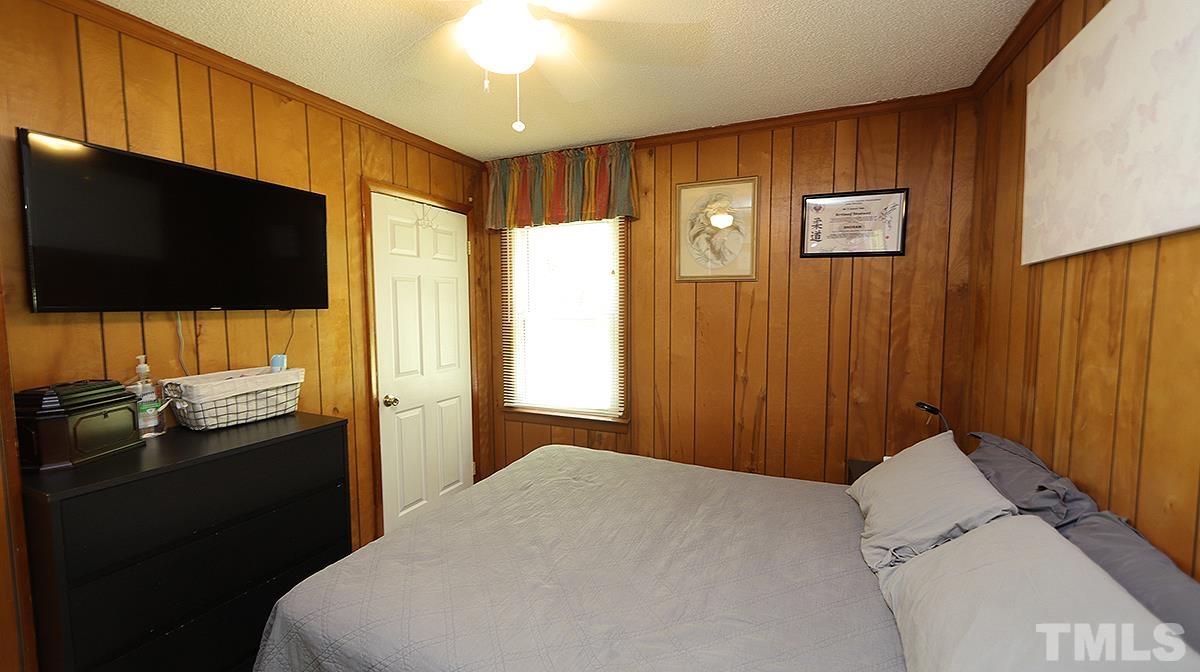 7121 Riley Hill Road Wendell, NC 27591 - Photo 8 of 16 a bedroom with a bed and a flat screen tv